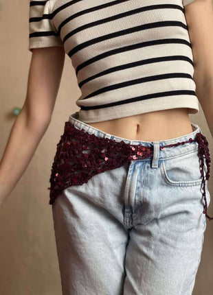 Red crochet bandana worn as a hip scarf over light jeans.