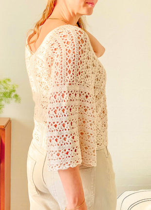 Side back view of the cream Magnolia Cardigan showing the lace sleeve and back panel.